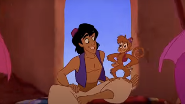 Un jeune homme souriant et animé est assis sur un tapis avec un singe joyeux sur son épaule, rappelant Aladin, à l'intérieur d'une pièce avec une fenêtre cintrée.