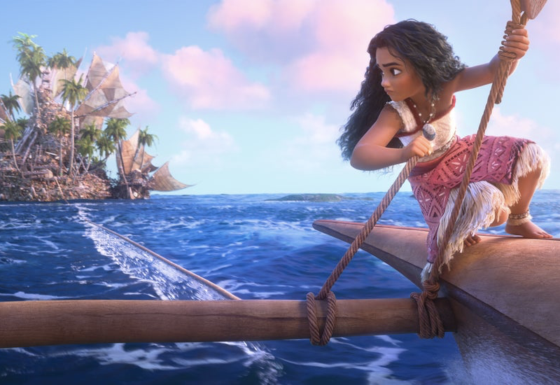 Une jeune fille navigue en canoë sur l'eau bleue claire de l'océan, rappelant une aventure Disney. En arrière-plan, une grande île avec des palmiers et des voiles fait allusion au monde de Vaiana 2.