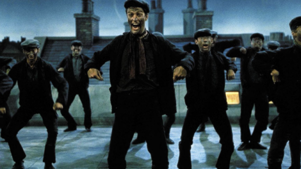 Un groupe de ramoneurs, marchant au rythme et dansant avec énergie sur un toit la nuit, portent des vêtements sombres et des casquettes plates. Le décor de cheminées imposantes sur fond de ciel bleu foncé donne le ton tandis qu'ils chantent joyeusement : « Prenons le rythme !