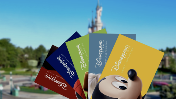 Quatre billets de Disneyland Paris présentent des motifs colorés, dont un représentant Mickey Mouse en gros plan. Un château flou sert de toile de fond enchanteresse.