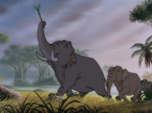 Trois éléphants animés, ressemblant à « la patrouille des éléphants », marchent en ligne dans une jungle, l'éléphant de devant tenant une branche dans sa trompe.