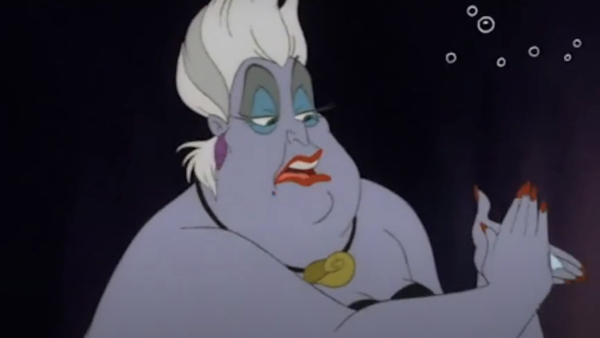 Un personnage animé à la peau pâle, aux cheveux blancs, au fard à paupières bleu et au rouge à lèvres rouge tient une note. Vêtue d'une tenue noire et d'un collier de coquillages sur un fond sombre, elle dégage un charme étrange rappelant celui des « pauvres âmes infortunées ».