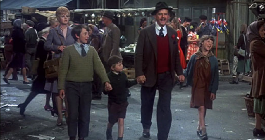 Un homme souriant portant un chapeau marche main dans la main avec trois enfants à travers le marché animé de Portobello Road, avec des vendeurs dynamiques et des acheteurs impatients qui s'affairent en arrière-plan.