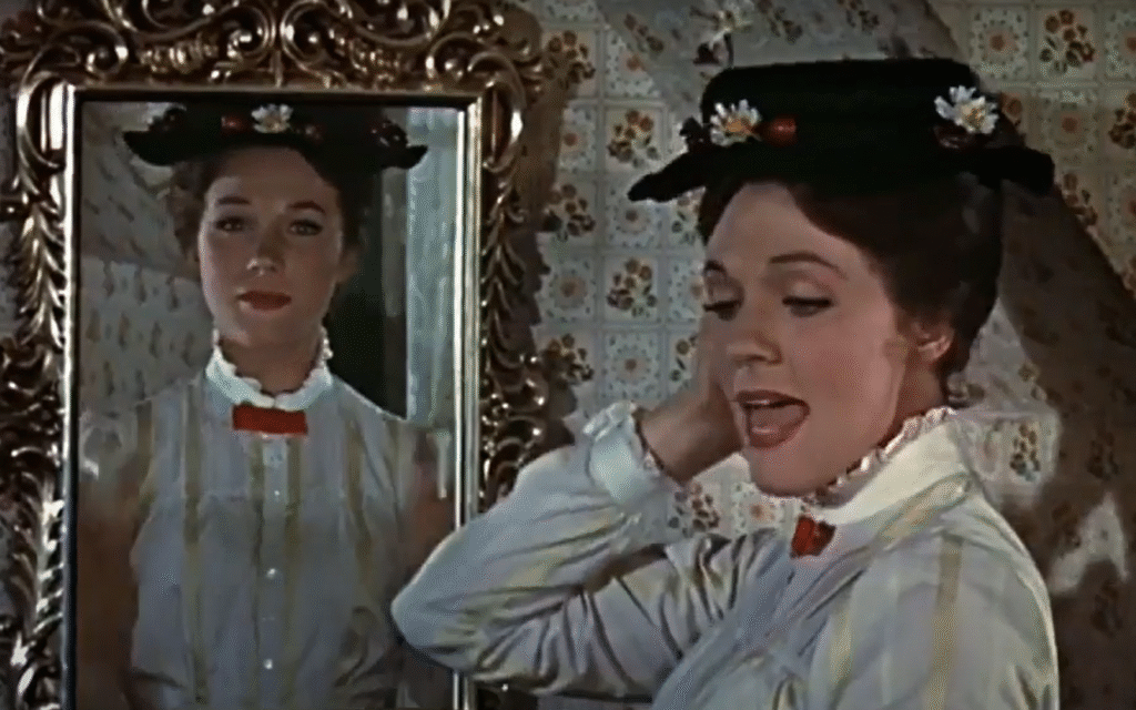 Une femme vêtue d'un chemisier blanc et d'un chapeau noir se tient à côté d'un miroir décoratif, son reflet visible derrière elle, comme si elle savourait un morceau de sucre dans un moment d'élégance tranquille.