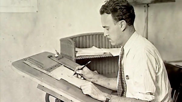 Un homme en chemise est assis à une table à dessin, dessinant ou écrivant sur du papier avec un stylo, rappelant Ub Iwerks au travail sur ses animations emblématiques.