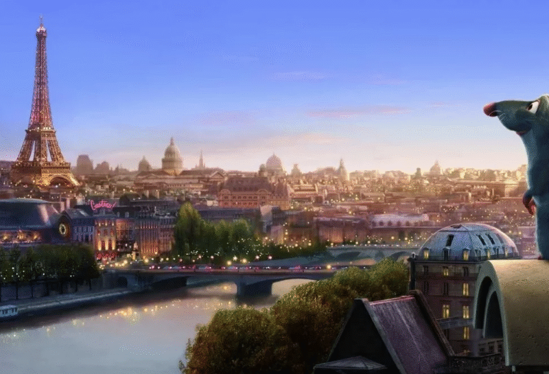 Un rat animé est assis sur un toit surplombant la Seine et la Tour Eiffel au coucher du soleil, tandis que "Le Festin" joue doucement en arrière-plan du paysage urbain stylisé de Paris.