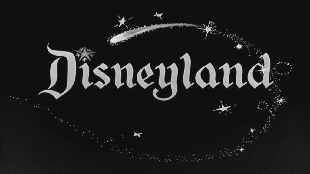 Fond noir avec le mot « Disneyland » en texte blanc stylisé, entouré d’étincelles, d’étoiles et d’une traînée semblable à une comète – rappelant la signature rapide de Zorro – formant un arc au-dessus du mot.