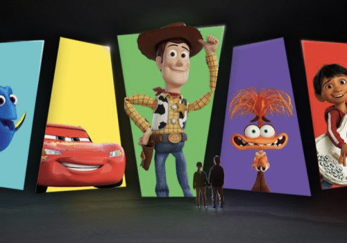 Cinq personnes se tiennent face à de grands écrans affichant les personnages bien-aimés de Pixar : Dory, Flash McQueen, Woody, une créature ressemblant à Muppet et un garçon avec une guitare.