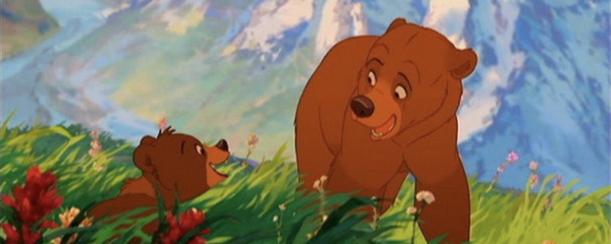 Deux ours bruns animés interagissent dans un champ d'herbe avec des fleurs colorées, avec pour toile de fond des sommets montagneux et un ciel bleu, rappelant Mon Frère Ours de la galaxie Disney.