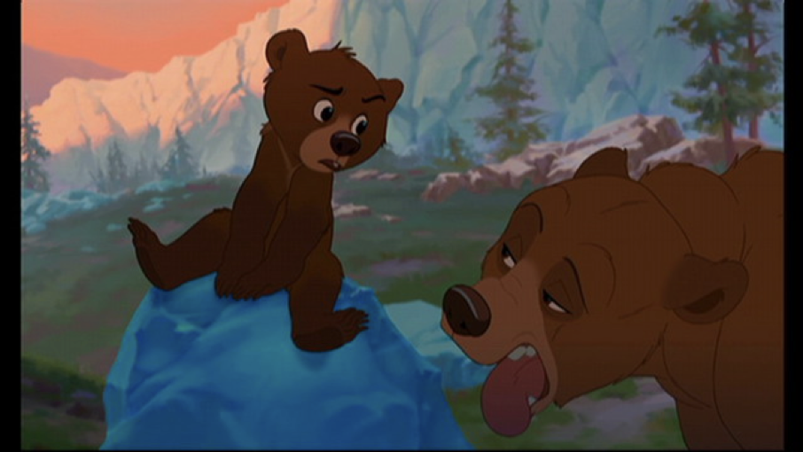 Scène animée de Mon Frère Ours : un ourson assis sur un rocher bleu regarde un ours adulte fatigué qui tire la langue, le tout dans une forêt montagneuse - un moment enchanteur dans la galaxie Disney.