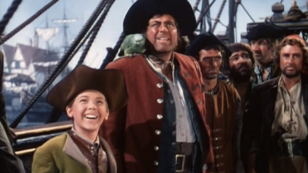 Un groupe d'hommes en tenue de pirate, dont un garçon souriant et un homme portant un perroquet sur l'épaule, se tient sur le pont du célèbre navire de l'Île au Trésor, regardant au loin avec une impatience aventureuse.