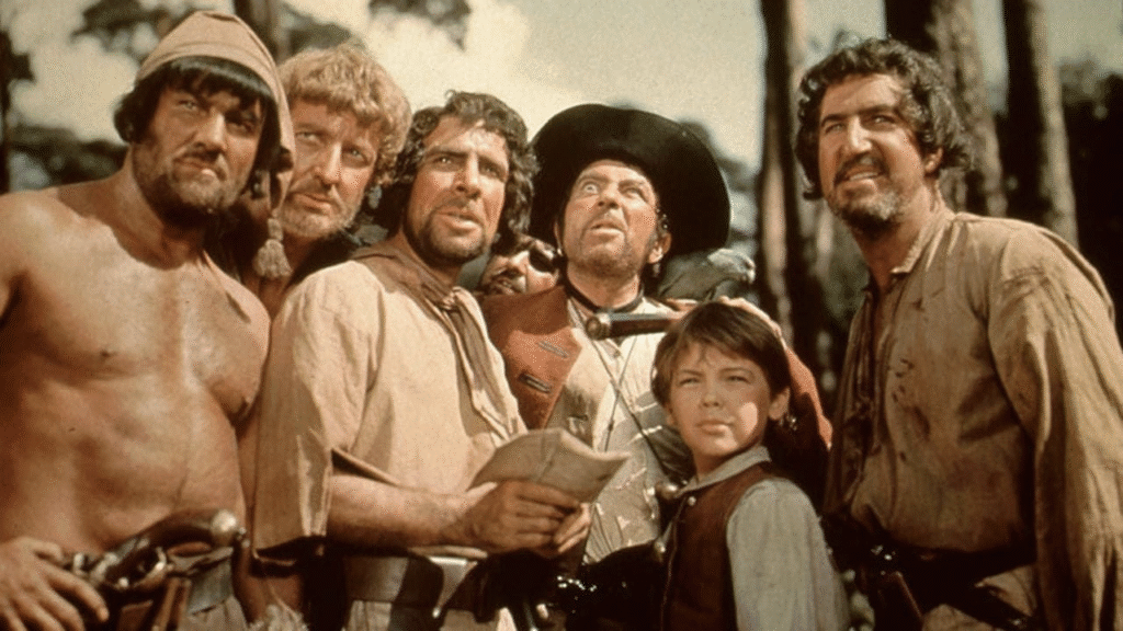 Un groupe de six hommes et un garçon, vêtus d'habits historiques ou de style pirate, se tiennent étroitement ensemble en plein air sur l'île au Trésor, regardant tous attentivement dans la même direction.