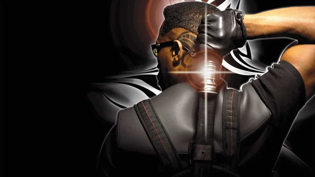Une personne en tenue tactique noire, évoquant le Blade de Marvel et le style emblématique de Mahershala Ali, porte des lunettes de soleil et tient la poignée d'une épée attachée à son dos, avec un dessin stylisé en arrière-plan.