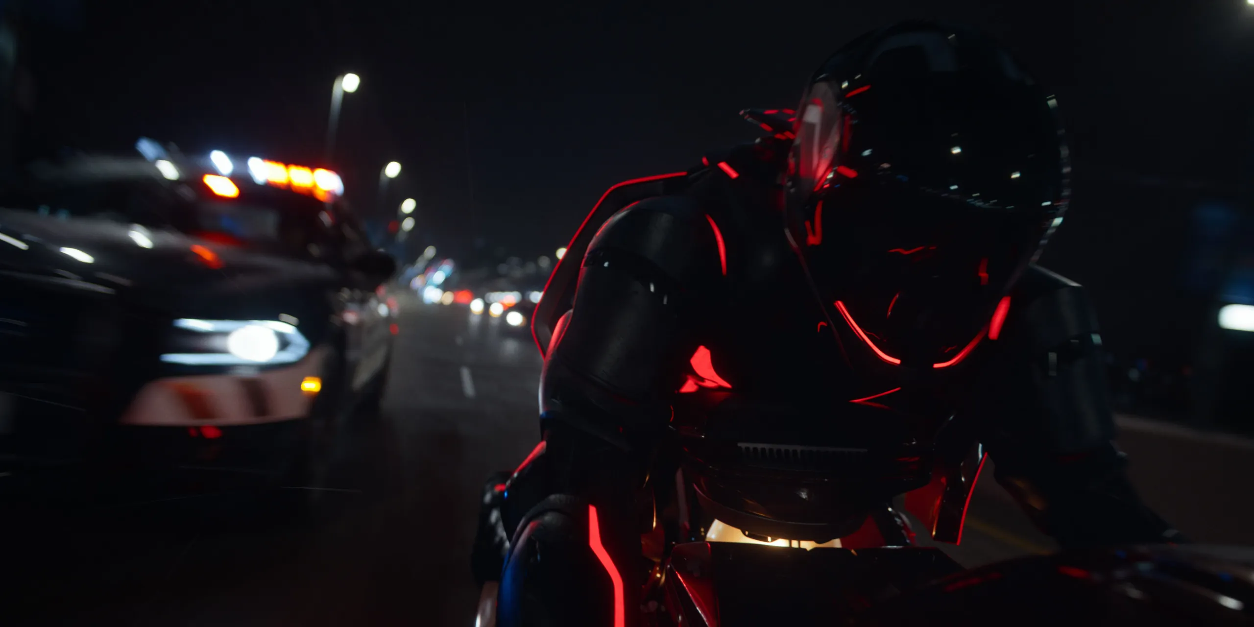 Une personne vêtue d'une combinaison noire futuriste avec des lumières rouges conduit une moto la nuit, poursuivie par une voiture de police dans une rue de la ville - évoquant les scènes de poursuite high-tech vues dans Tron : Ares de Disney avant sa date de sortie.