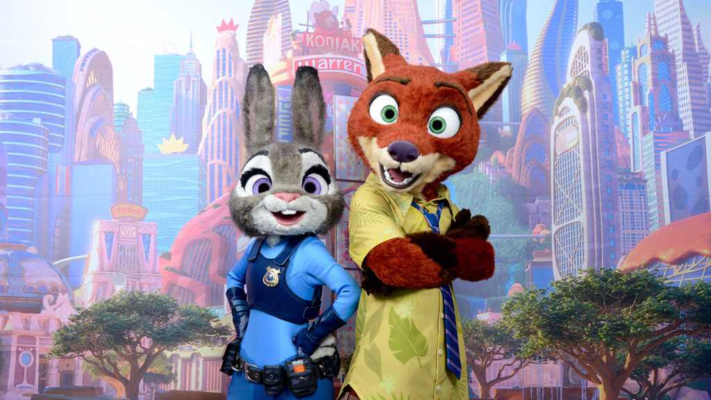 Deux personnages costumés de Zootopie, un lapin gris en uniforme de police et un renard roux en chemise jaune, se tiennent dos à dos devant un paysage urbain coloré, créant un spectacle accrocheur qui rappelle Animal Kingdom.