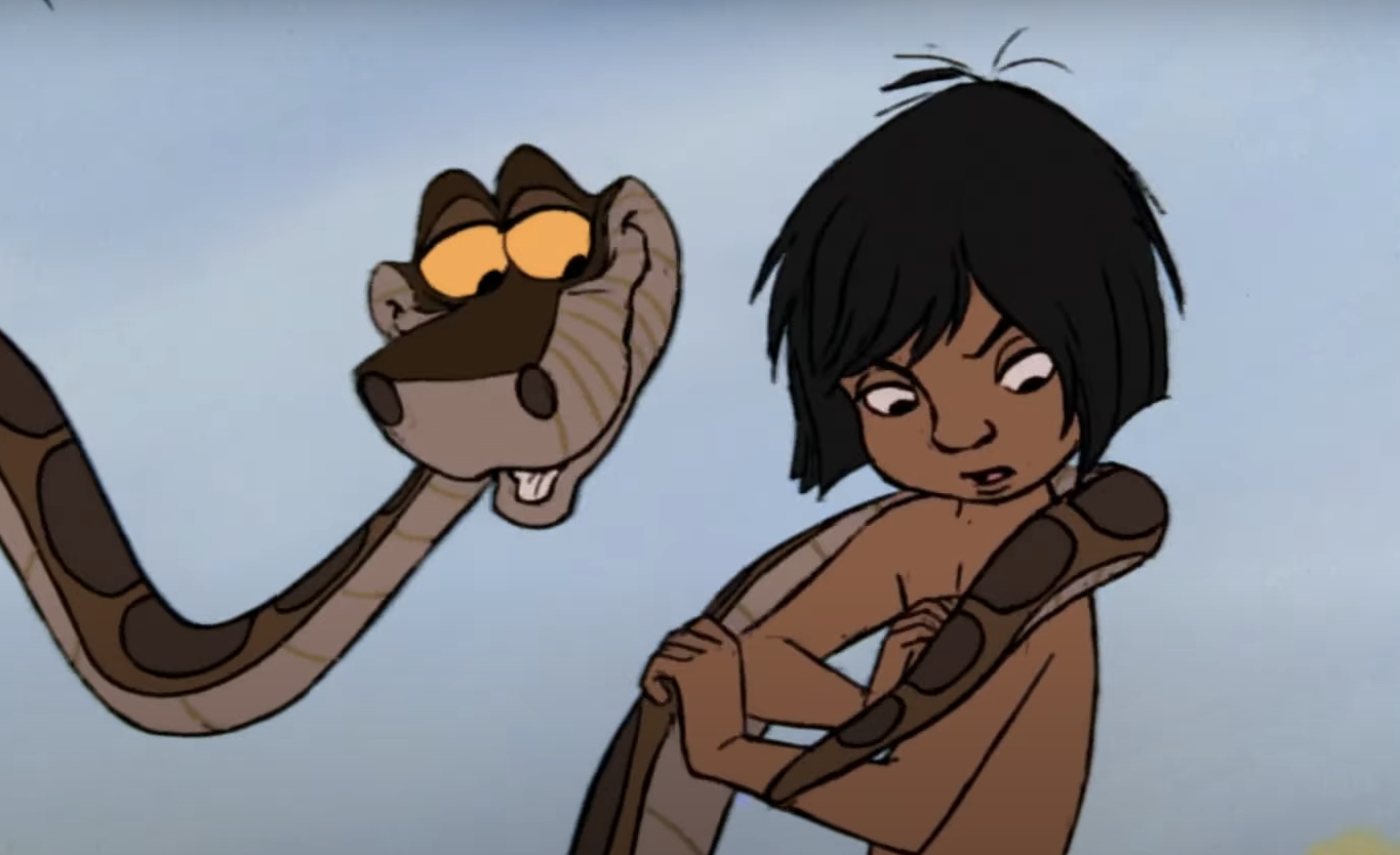 Un garçon animé aux cheveux noirs est enveloppé par un grand serpent qui le regarde en souriant et en murmurant "aie confiance". L'arrière-plan est un simple ciel bleu.