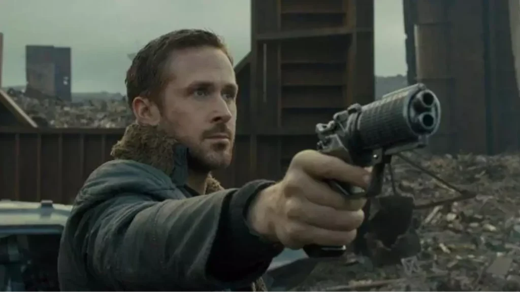 Un homme aux cheveux courts et à la barbe taillée pointe un pistolet futuriste vers l'avant, debout dans un décor industriel jonché de débris, rappelant Ryan Gosling dans une superproduction d'aventures galactiques.