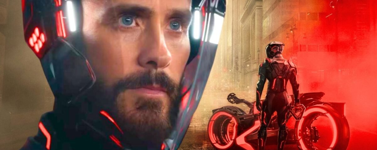 Un homme portant un casque futuriste est montré de près, avec une moto éclairée au néon et une personne portant un costume similaire dans une rue brumeuse et éclairée en rouge de la ville. Cette image évoque l'univers high-tech de Tron : Ares de Disney.