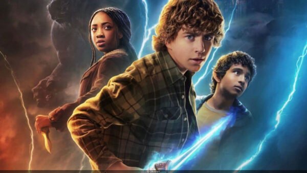 Trois jeunes gens se tiennent ensemble, chacun tenant une arme, tandis que des éclairs bleus et orange crépitent derrière eux dans cette scène saisissante de la bande-annonce de Percy Jackson Saison 2 sur Disney+.