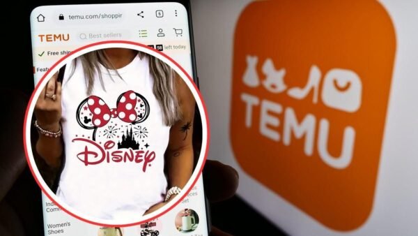 Un téléphone affiche l'application de shopping Temu avec un débardeur à l'effigie de Disney, suggérant une possible contrefaçon ; le logo Temu est visible à l'arrière-plan.