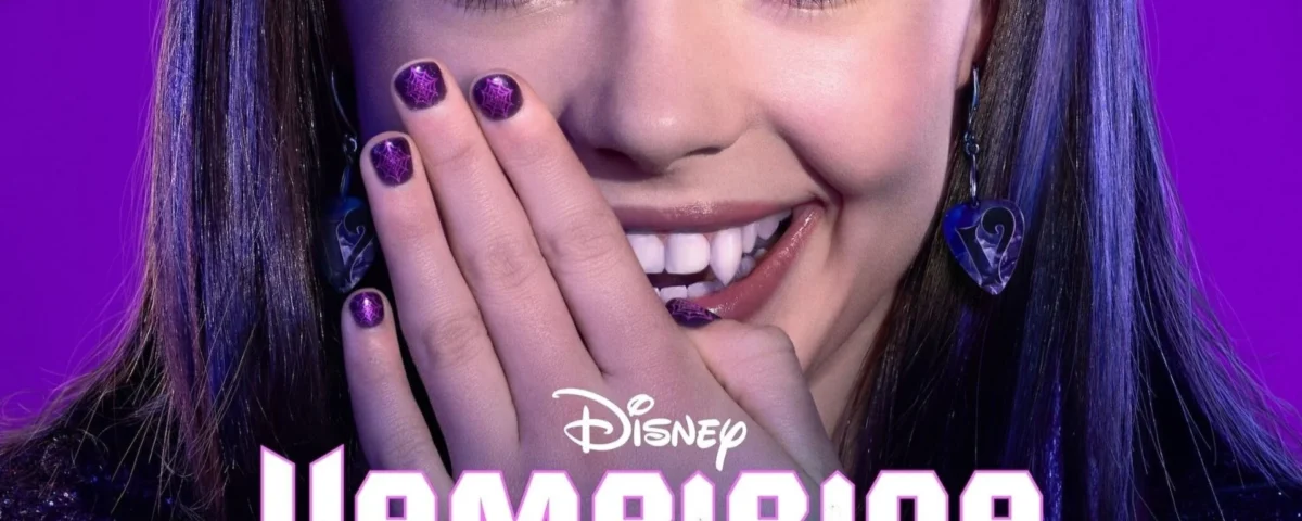 Une jeune fille aux yeux violets et au vernis à ongles violet assorti sourit en couvrant une partie de sa bouche avec sa main. Le texte "Disney Vampirina", inspiré de la série musicale diffusée sur Disney Channel, apparaît en bas.