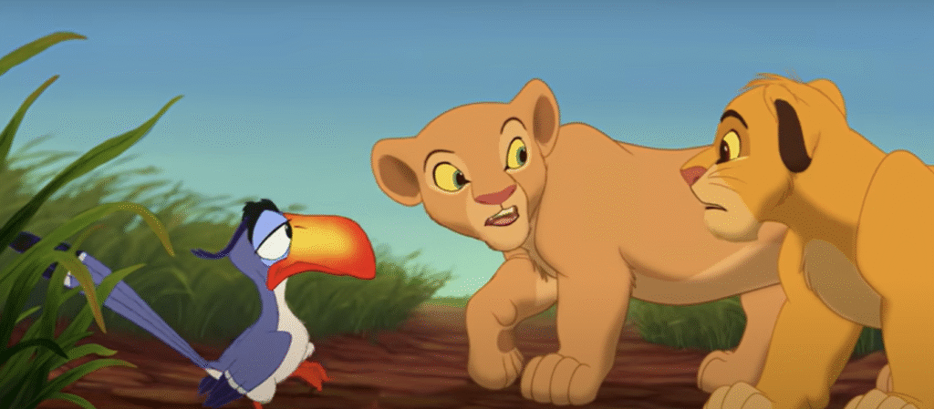 Un lionceau, une lionne et un calao de dessin animé se tiennent ensemble à l'extérieur, semblant tous engagés dans une conversation tendue, comme s'ils se préparaient -soyez prêtes- à ce qui va suivre.