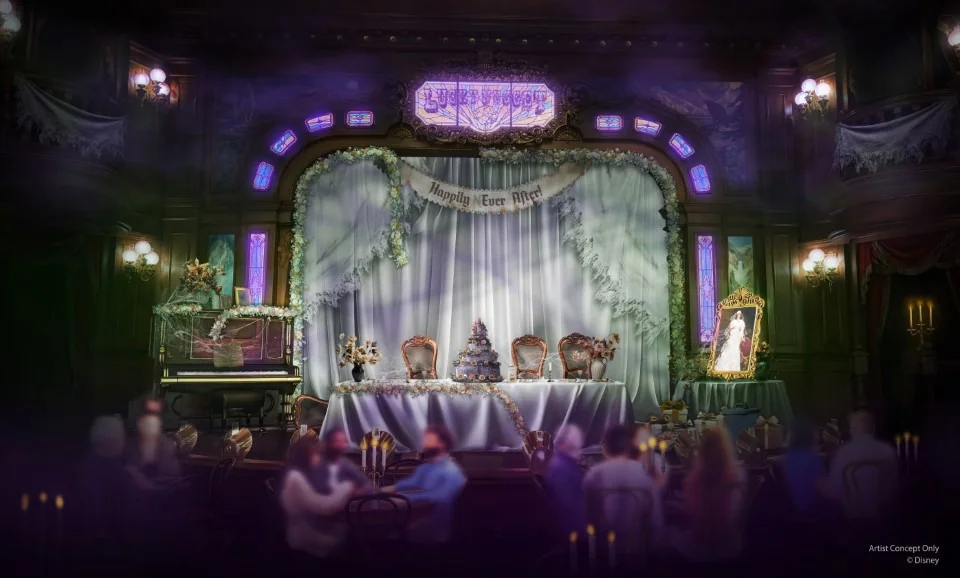 Une salle ornée et faiblement éclairée de Disneyland Paris présente une table décorée sur une scène, un piano, des couronnes festives et un portrait inquiétant - capturant l'esprit d'Halloween Disney 2025 - avec des invités assis au premier plan.