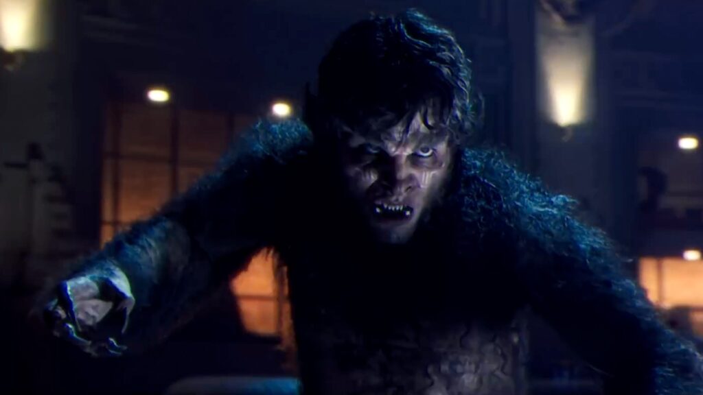 Une personne aux traits de loup-garou, rappelant le loup-garou de nuit du MCU de Marvel, est accroupie avec une expression intense dans une pièce faiblement éclairée.