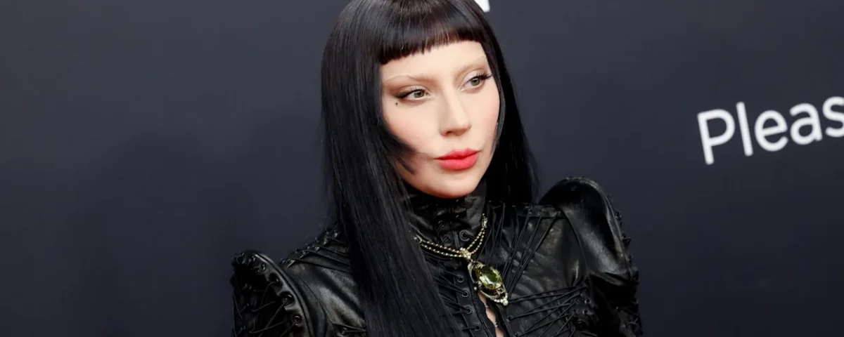 Une personne portant une tenue en cuir noir, de longs cheveux noirs et une frange émoussée, prenant la pose devant un arrière-plan sombre. Le Diable s'habille en Prada a été l'un des principaux symboles de l'événement.