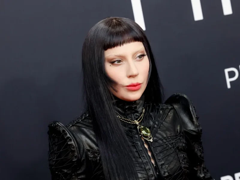 Une personne portant une tenue en cuir noir, de longs cheveux noirs et une frange émoussée, prenant la pose devant un arrière-plan sombre. Le Diable s'habille en Prada a été l'un des principaux symboles de l'événement.