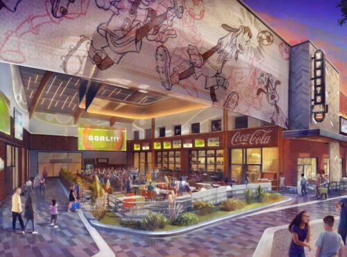 Un espace de restauration en plein air animé à Disney Village avec des personnes assises à des tables, de grands écrans de sport et une fresque de personnages de dessins animés au-dessus du bâtiment - parfait pour profiter de l'atmosphère vibrante de ce Sports Bar & Lounge près de Disneyland Paris.