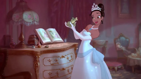 Une femme animée ressemblant à Tiana de Disney, vêtue d'une robe blanche et d'un diadème, tient une grenouille, debout à côté d'un bureau orné d'un livre ouvert - parfait pour une liste de naissance magique, dans une pièce élégante faiblement éclairée.