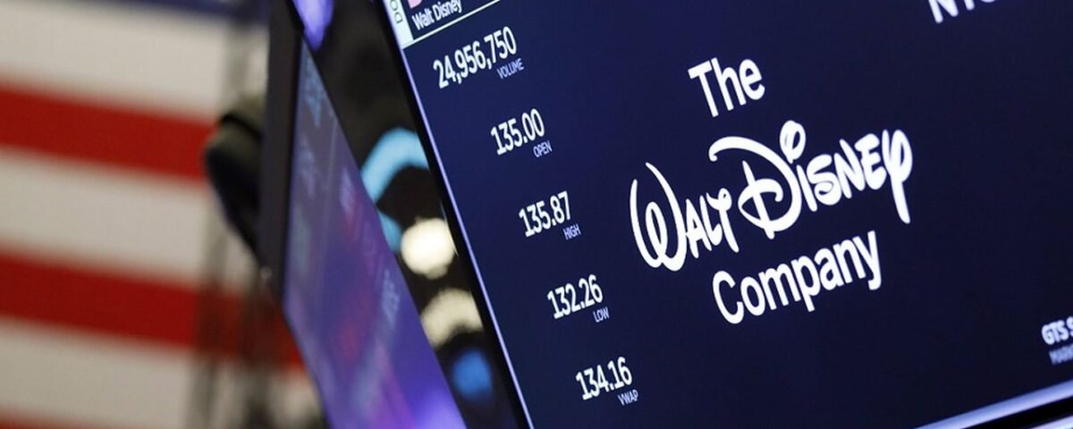 Un écran de la Bourse de New York montre le logo de Disney, des données boursières reflétant les résultats décevants et un drapeau américain en arrière-plan.