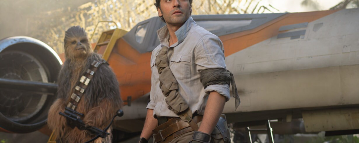 Un homme en tenue robuste se tient devant un vaisseau spatial de la Guerre des étoiles, à côté d'un grand personnage à fourrure tenant une arme, avec des arbres et de la brume en arrière-plan.