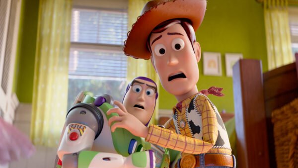 Woody et Buzz l'Éclair du film Toy Story de Pixar ont l'air surpris alors qu'ils se tiennent l'un près de l'autre dans une pièce très éclairée, ce qui laisse présager de nouvelles aventures dans Toy Story 5.