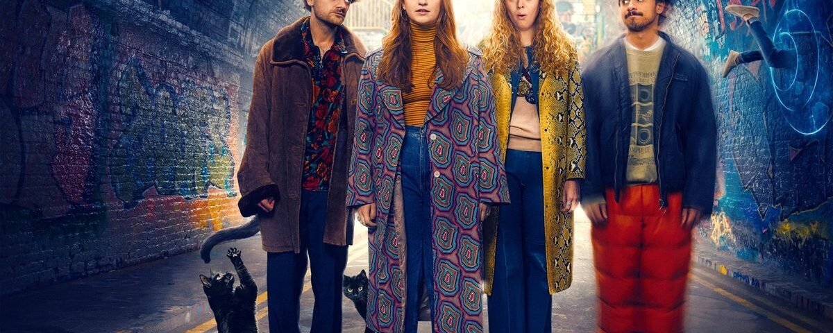 Quatre jeunes adultes se tiennent dans un tunnel couvert de graffitis, deux chats noirs à leurs pieds, tous vêtus de tenues colorées et excentriques, regardant vers l'avant avec des expressions neutres, comme s'ils étaient prêts à vivre une aventure extraordinaire dans une série comique de Disney.