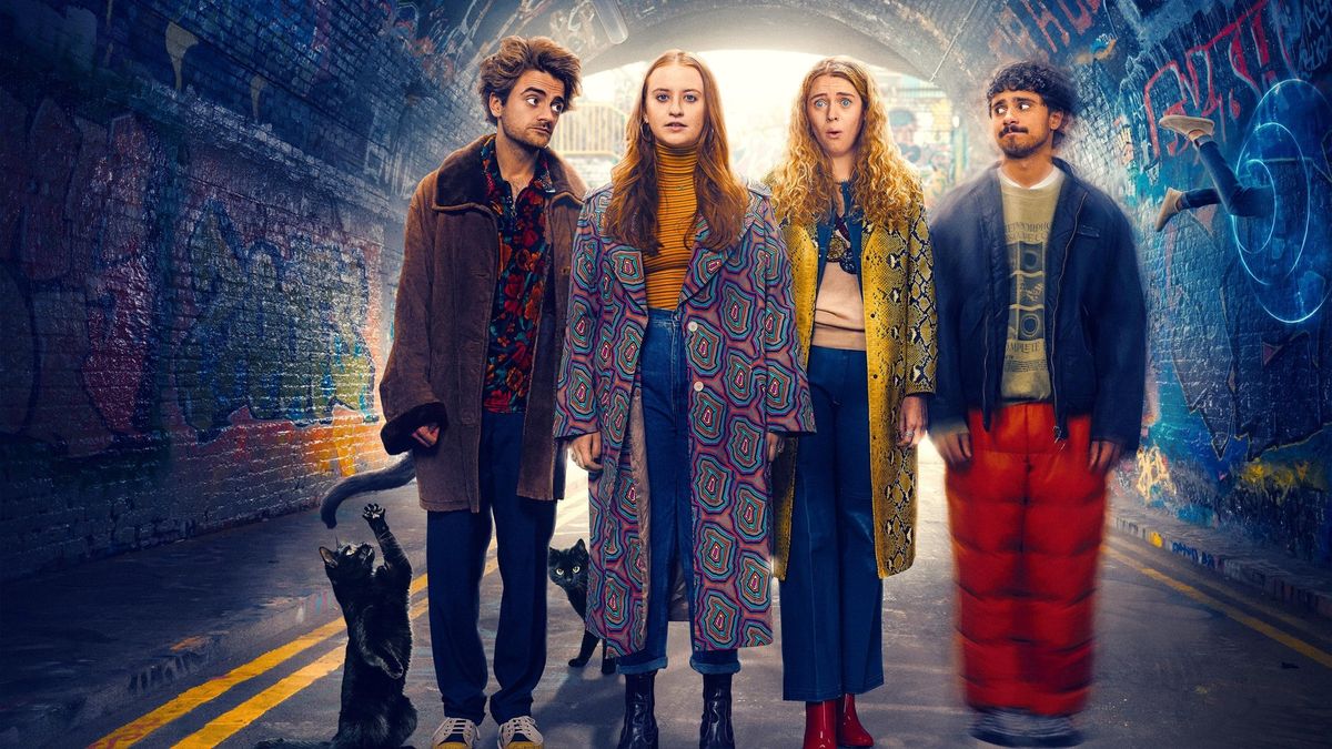 Quatre jeunes adultes se tiennent dans un tunnel couvert de graffitis, deux chats noirs à leurs pieds, tous vêtus de tenues colorées et excentriques, regardant vers l'avant avec des expressions neutres, comme s'ils étaient prêts à vivre une aventure extraordinaire dans une série comique de Disney.