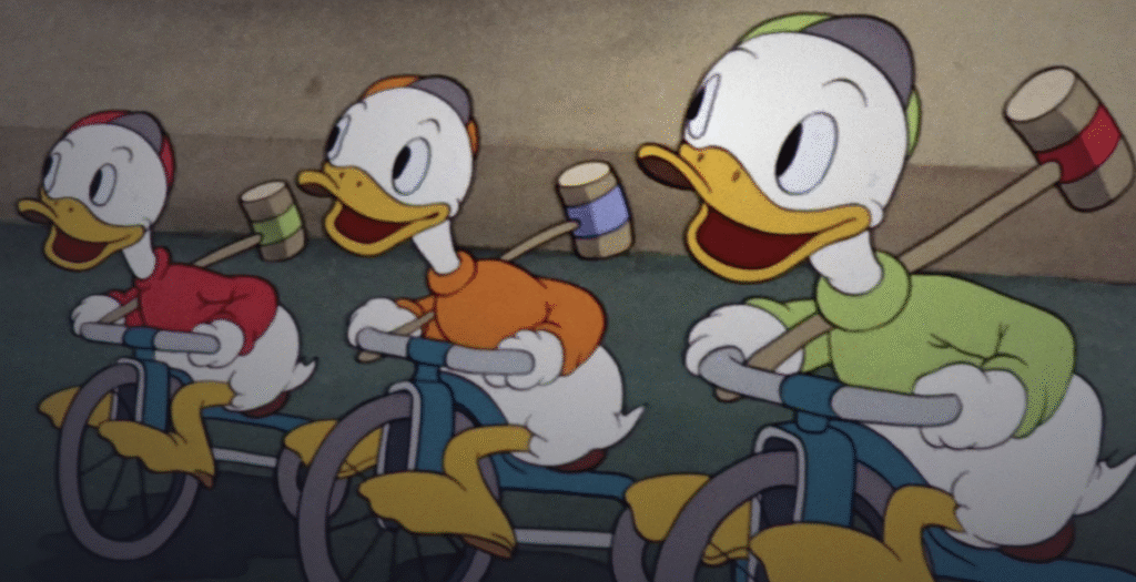 Trois canetons animés - Riri en rouge et ses copains en chemise orange et verte - se déplacent à bicyclette, un maillet de croquet sur l'épaule.