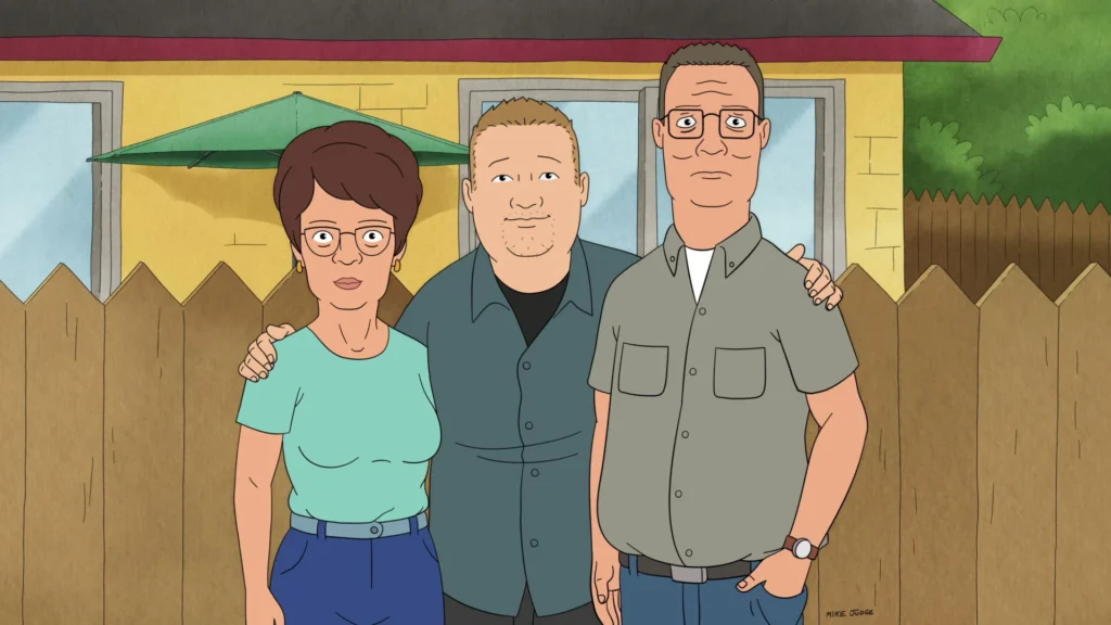 Trois adultes animés se tiennent en plein air devant une clôture en bois et une maison, posant pour une photo de groupe - une scène classique rappelant King Of The Hill.