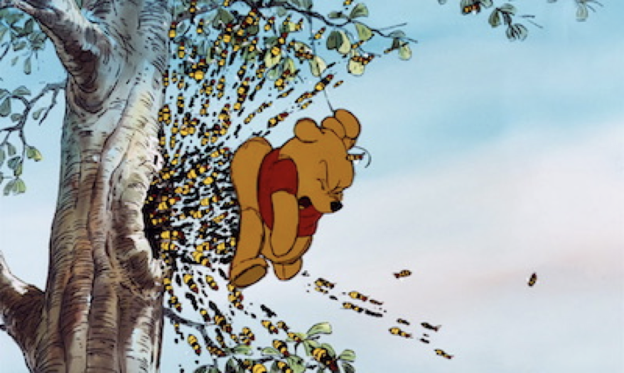 Un ours de dessin animé en chemise rouge, Winnie l'Ourson, est suspendu à un arbre tandis qu'un grand essaim d'abeilles s'envole d'un trou dans le tronc, comme lors de sa sortie première le 4 février 1966.