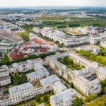Vue aérienne de Val d'Europe montrant des maisons blanches, des espaces verts luxuriants, des routes bien planifiées et des entreprises éloignées.