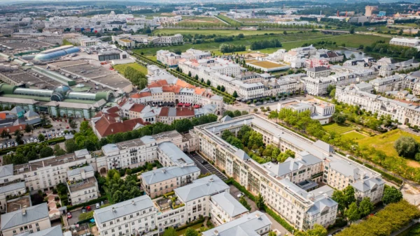 Vue aérienne de Val d'Europe montrant des maisons blanches, des espaces verts luxuriants, des routes bien planifiées et des entreprises éloignées.