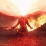 Une personne vêtue d'un costume rouge est agenouillée sur le sol, émettant un large faisceau d'énergie à partir de ses yeux dans un environnement enflammé et enfumé - rappelant les teasers dramatiques d'Avengers Doomsday.