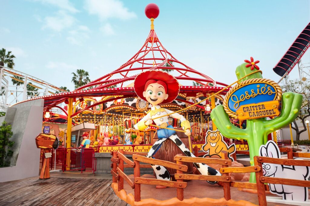 Un carrousel coloré sur le thème de Jessie de Toy Story, conçu par les Imagineers, avec une grande statue de Jessie, des figurines d'animaux de dessins animés et des lumières vives à Disney California Adventure.