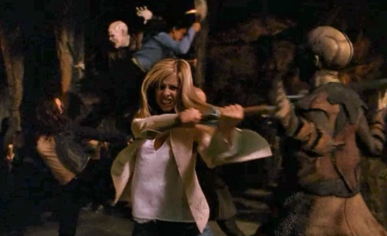 Une femme, qui rappelle Buffy, brandit un pieu en bois et combat des personnages monstrueux dans un environnement sombre et chaotique qui rappelle Sunnydale.