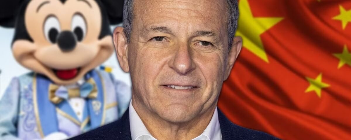 Un homme se tient devant un personnage de Mickey Mouse et un drapeau chinois, mettant en avant Disney en Chine et ses ambitions en matière d'investissement Disney.