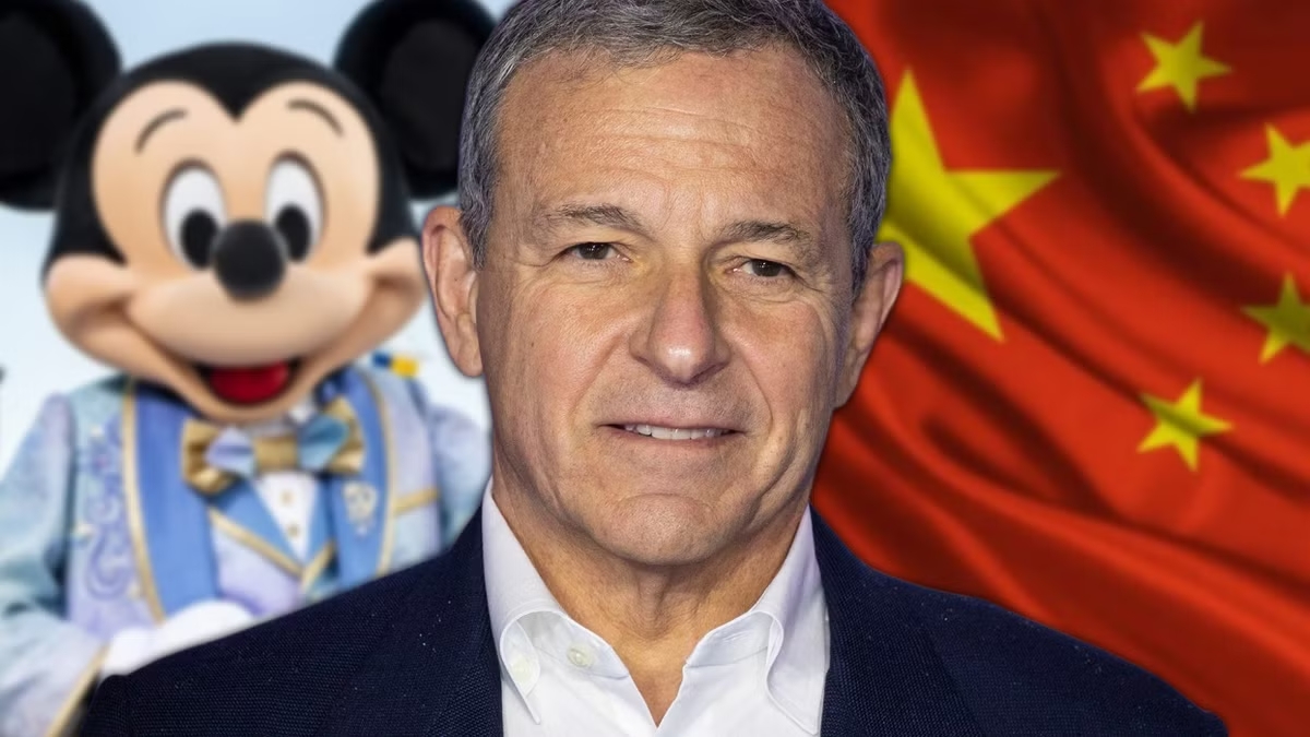 Un homme se tient devant un personnage de Mickey Mouse et un drapeau chinois, mettant en avant Disney en Chine et ses ambitions en matière d'investissement Disney.