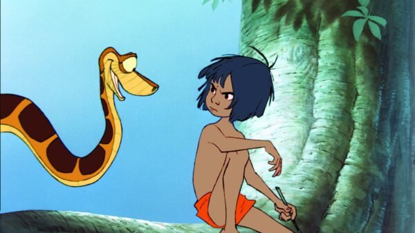 Un jeune garçon aux cheveux noirs et au short orange est assis sur une branche d'arbre, tenant un bâton, face à un grand serpent jaune et brun. La lumière du soleil filtre à travers les feuilles, évoquant la magie de Disney et célébrant la diversité de la nature.