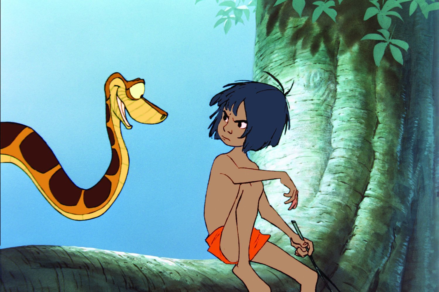 Un jeune garçon aux cheveux noirs et au short orange est assis sur une branche d'arbre, tenant un bâton, face à un grand serpent jaune et brun. La lumière du soleil filtre à travers les feuilles, évoquant la magie de Disney et célébrant la diversité de la nature.