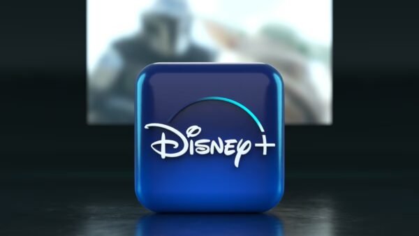 Une icône bleue du logo Disney+ apparaît au premier plan, soulignant la présence de Disney dans le domaine de la diffusion en continu, avec une scène floue d'une émission de télévision ou d'un film visible sur un écran à l'arrière-plan.